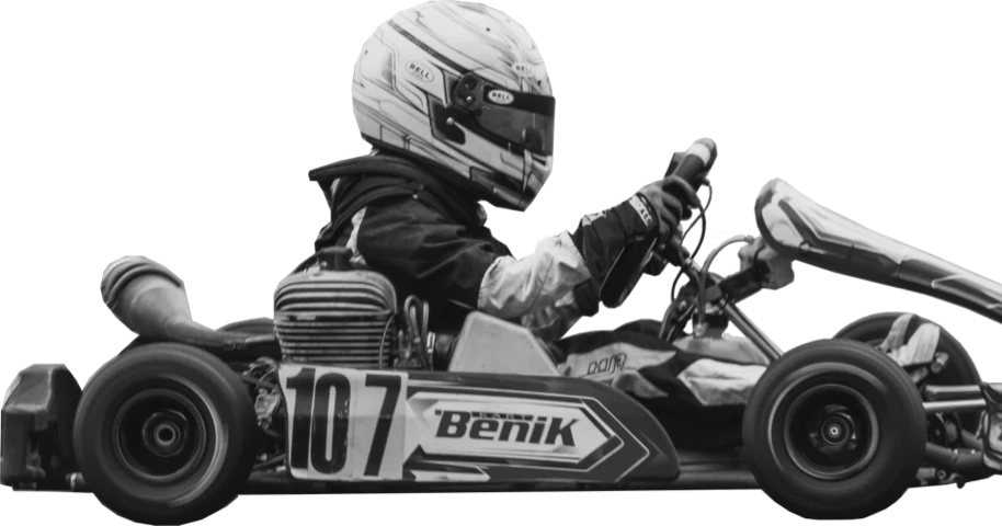 Imagem de uma pessoa sentada sobre um kart de corrida em preto e branco